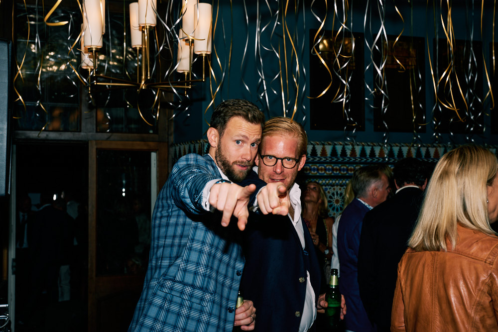 Eventfotograf-stockholm-40-årsfest-två-manliga gäster-pekar-mot-kameran