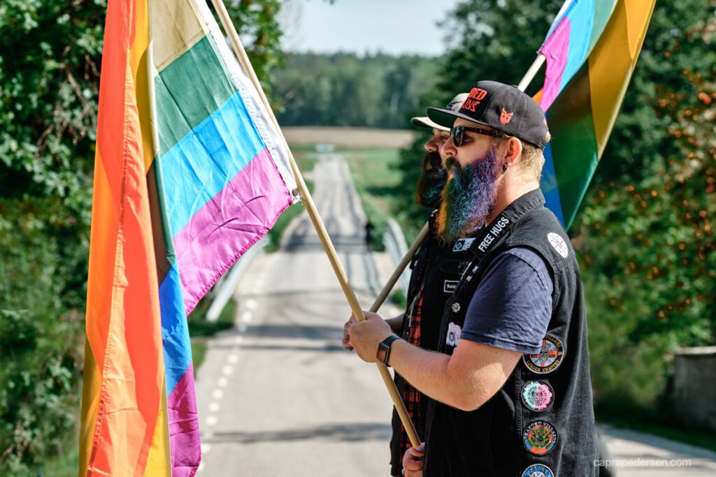 pridefestival-i-gnesta-två-skäggiga-män-med -flaggor-